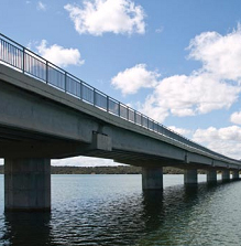 A large bridge is shown over a body of water.