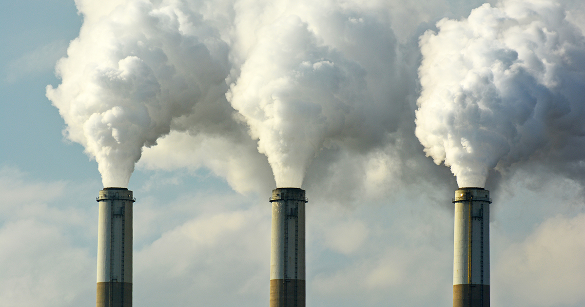 Multiple coal power plant smokestacks emit pollution.
