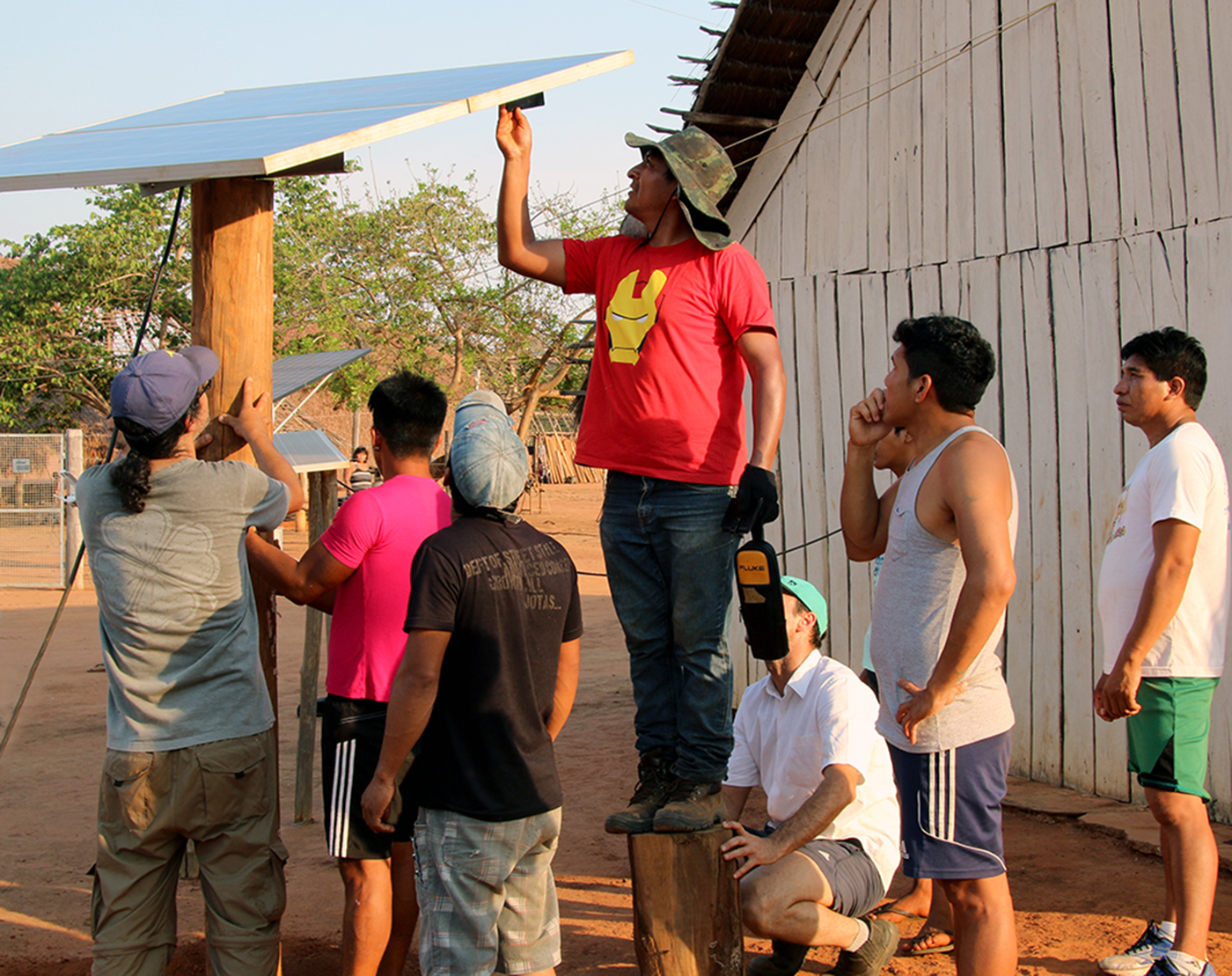Men from the Xingu Indigenous Park install a solar panel in the village of Pyulaga. Photo: Neal Hegarty