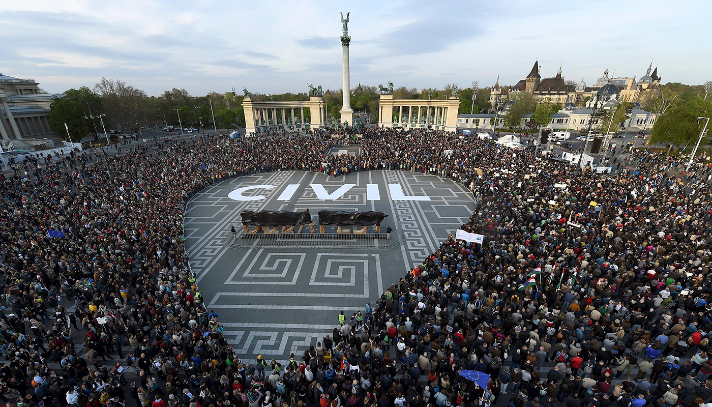 Protesters at Heroes' Square in Budapest form the shape of a heart with the word "CIVIL" in white letters on the ground in the center of the heart.