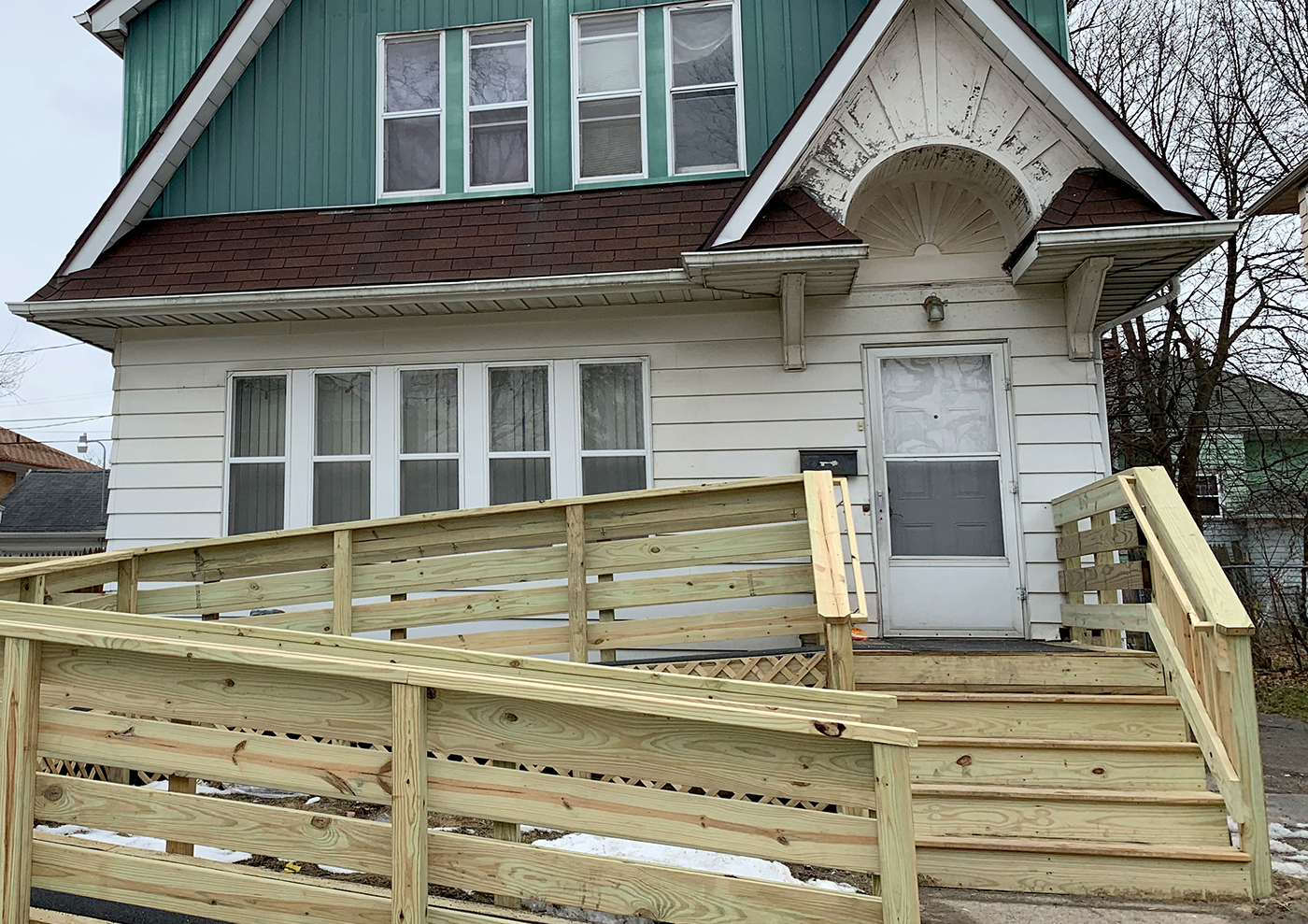 A house in Flint, Michigan, that has a brand new wheel chair ramp in front of it.