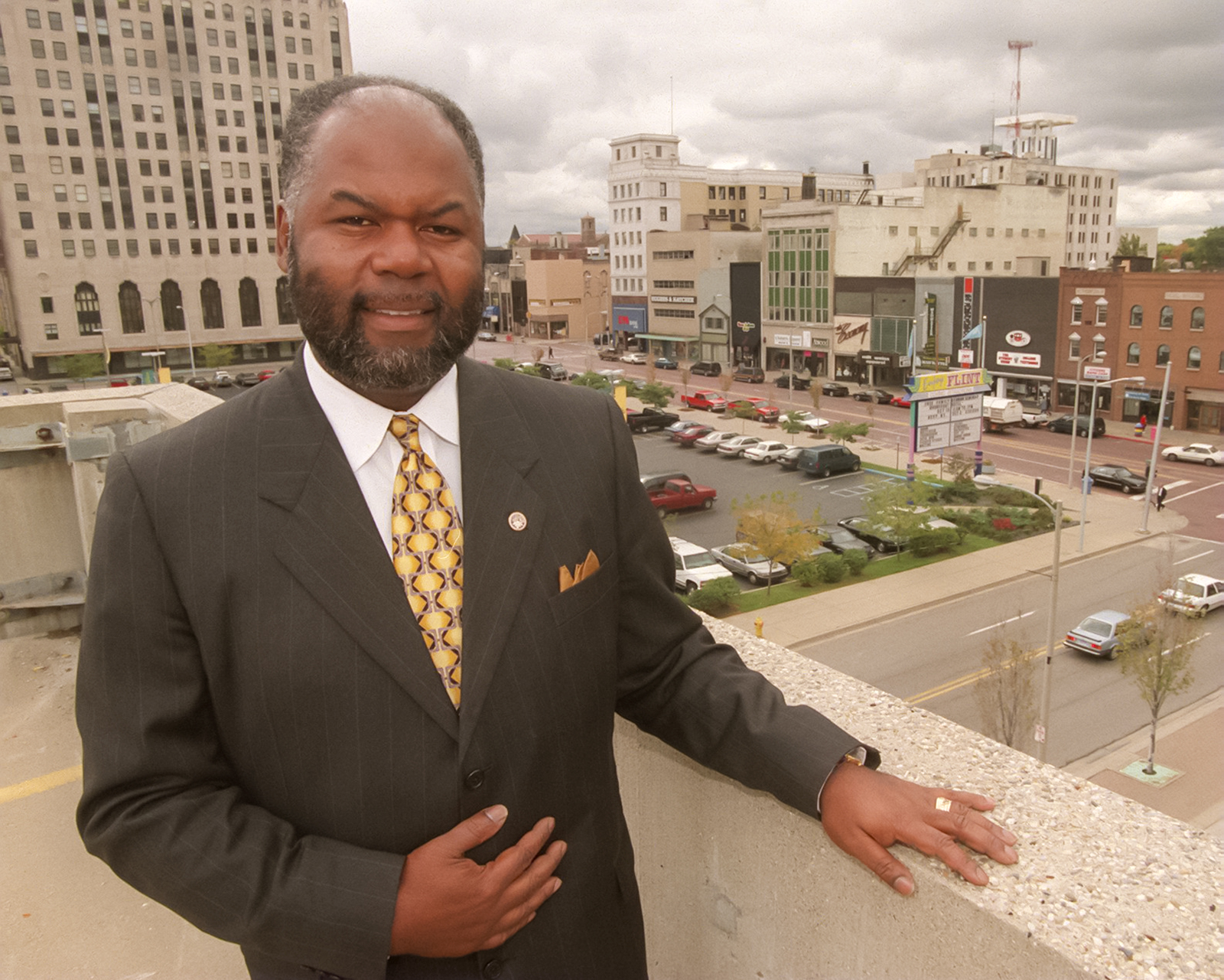 Mayor Woodrow Stanley stands in front of a downtown Flint streetscape.