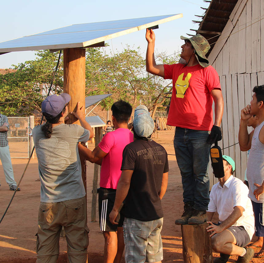 A group of men install a solar panel in Pyulaga Village.