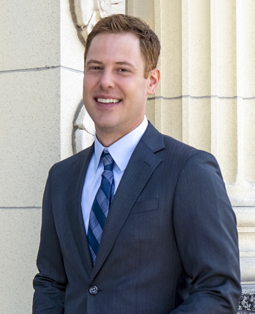 A young man poses for a photo wearing a suit and tie.