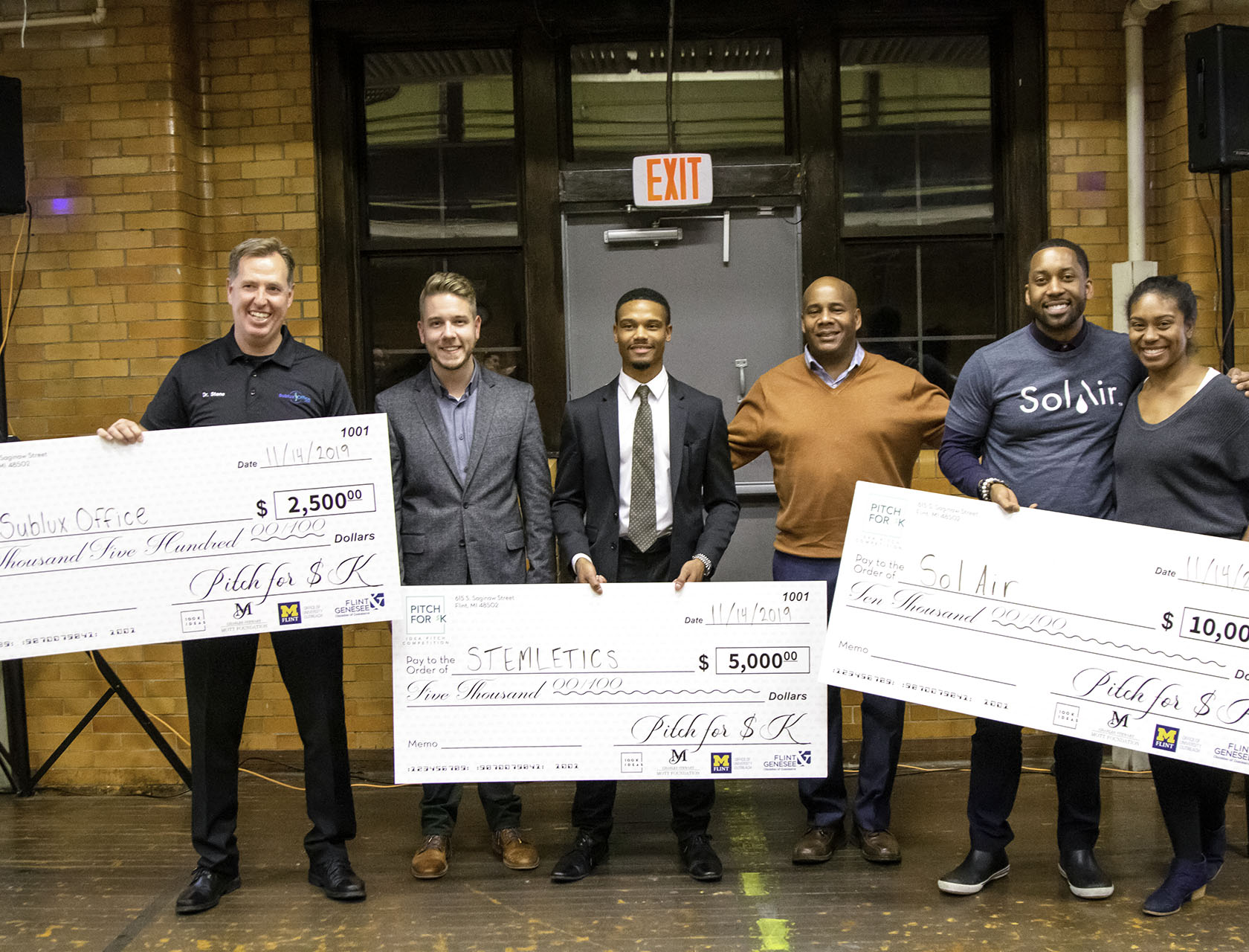 Chris Stallworth poses with winners of a Pitch For $K competition in 2019 that took place at Berston Filed House in Flint, Michigan.