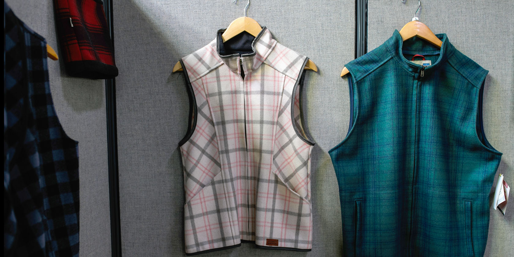 Finished vests made by the St. Luke N.E.W. Life Center sewers are displayed on a wall.