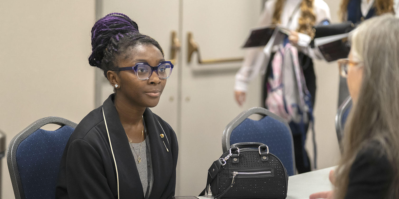 Photo of Kimori sitting at a table and speaking with a mentor.