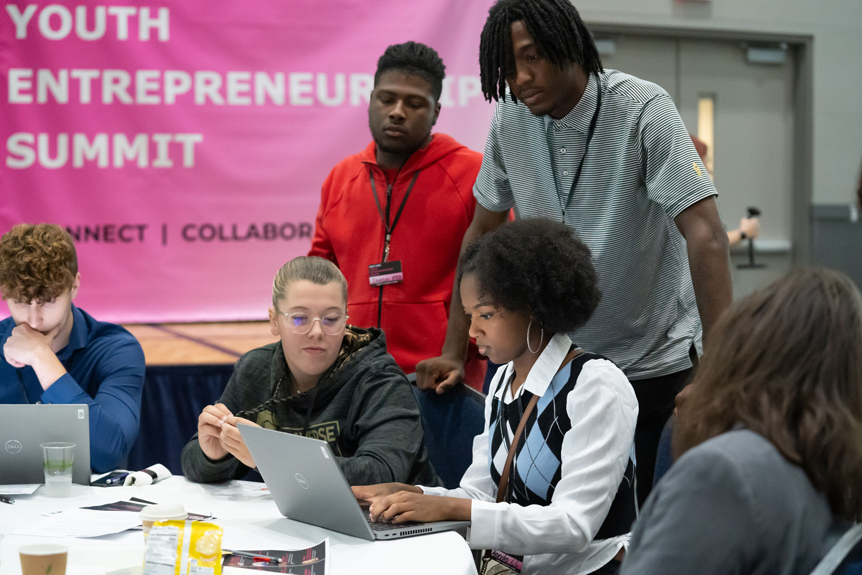 A group of young people that attended the NextGen Youth Entrepreneurship Summit event work on their ideas to present to their peers and judges.