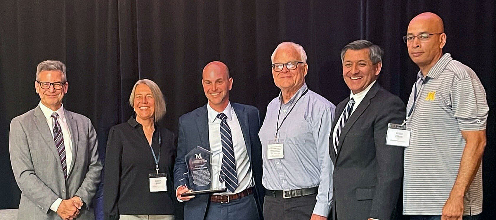CSA experts pose for a group photo with an award for the Mott Foundation president
