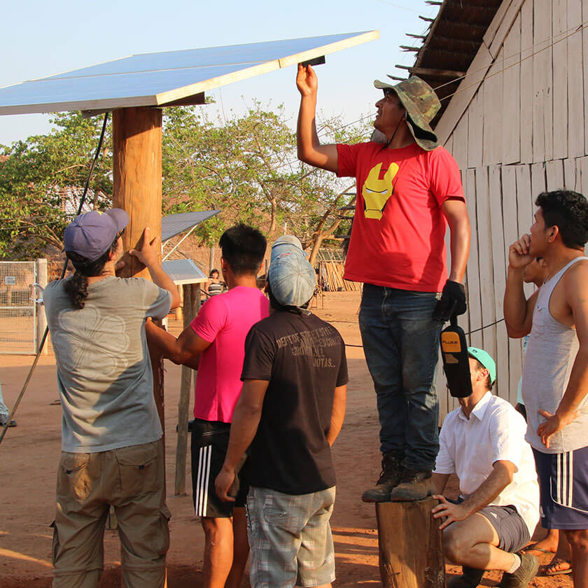 Men from the Xingu Indigenous Park install a solar panel in the village of Pyulaga.