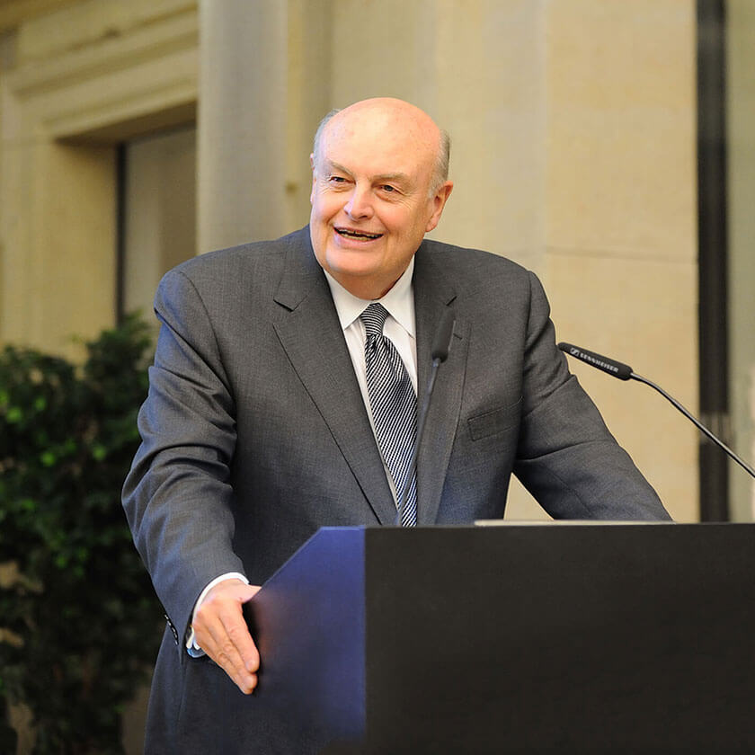 William White stands at a podium speaking into a microphone.