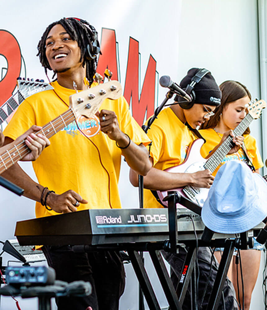 A group of students on a stage play musical instruments.