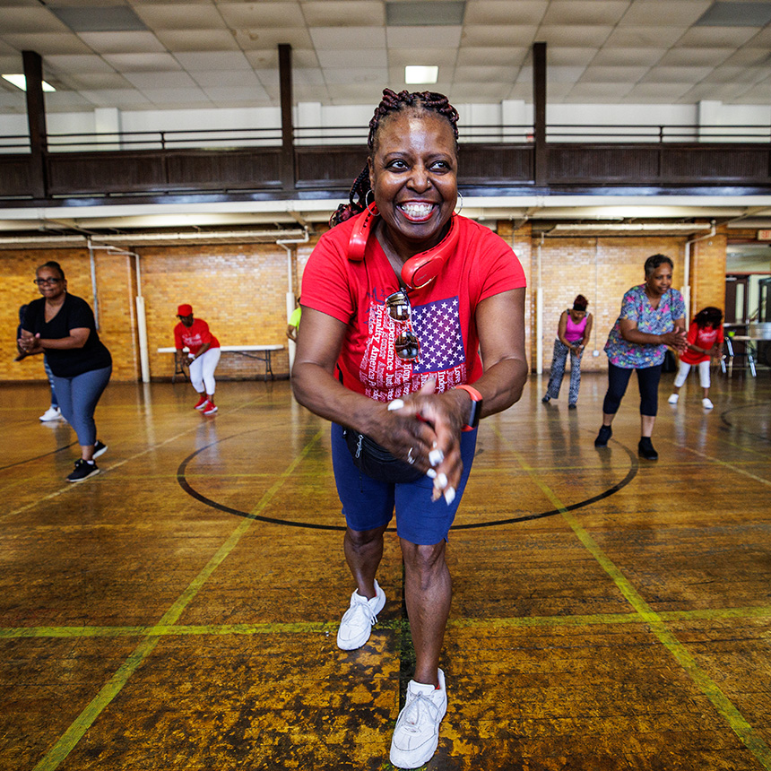 A woman dressed in athletic shoes, blue short and a red tshirt with the American flag on it.
