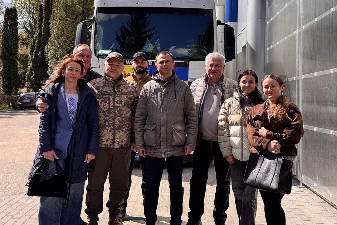 Group of community members and responders stand in front of a delivery truck, representing coordinated logistics and delivery of humanitarian aid supplies supported by a community foundation in response to the war in Ukraine.