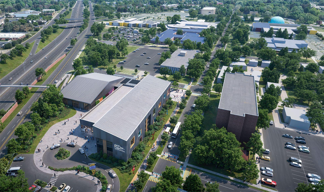 Aerial rendering of FCC Academy Upper School campus showing the rectangular school two level building with light-colored roofs connected by walkways, surrounded by trees, parking areas, and nearby streets. Groups of people are visible along sidewalks and crosswalks, and the surrounding neighborhood includes additional buildings, green spaces, and a large roadway adjacent to the campus.