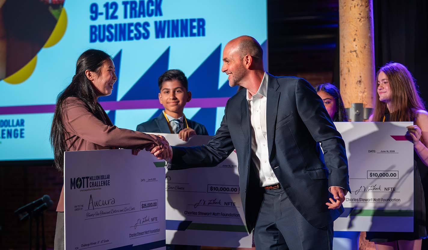 Mott Foundation President and CEO Ridgway White shakes hands with Kayley, creator of Aucura, during the Mott Million Dollar Challenge awards ceremony.