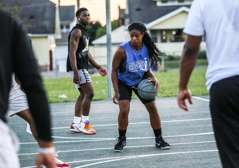 Young people play basketball in a park located in the city of Flint.